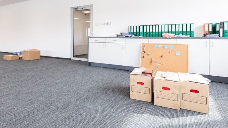 Cajas de archivo y carpetas en una oficina vacía, listas para el traslado